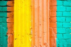 vermelho, laranja, amarelo e azul cor combinação velho texturizado danificar parede com colorida tijolos. foto