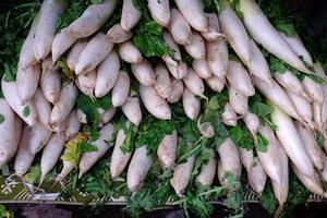 pilha do branco daikon rabanete dentro a japonês mercado. foto