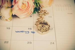palavra Casamento em calendário e ouro pulseira com coração foto