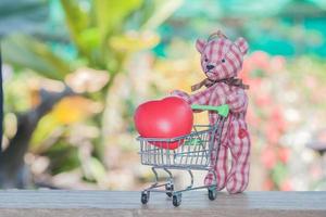 vermelho coração bola dentro compras carrinho com Urso brinquedo foto