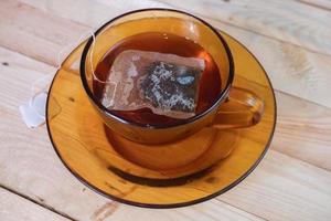 Saquinho de chá dentro vidro em de madeira mesa foto