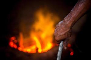 inseguro trabalhador mãos. uma local aço máquina partes fazer Jardim trabalhador Derretendo sucatear em quente forno. foto