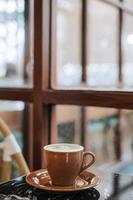 matcha café com leite em uma Preto mármore mesa perto a janela foto