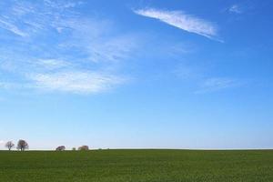 lindo minimalista Primavera panorama avião com verde prados azul céu com branco nuvens foto