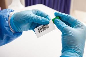 fechar-se do uma enfermeira marcação uma teste tubo com sangue amostra dentro uma clínico laboratório foto