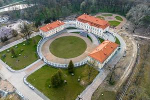 aéreo Visão em negligenciar restauração do a histórico castelo ou Palácio perto lago foto