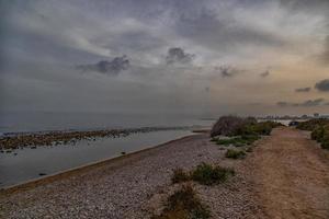 beira-mar panorama com pôr do sol alicante Espanha com nuvens dentro a céu foto