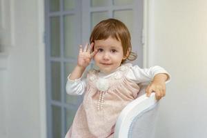 pequeno menina sentado em moderno cadeira foto