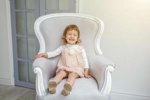 pequeno menina sentado em moderno cadeira foto
