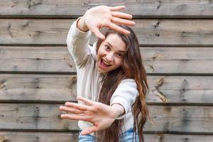 garota feliz sorrindo. retrato de beleza jovem feliz positiva rindo mulher morena no fundo da parede de madeira foto