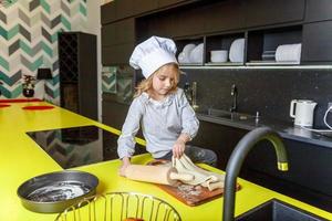 pequeno menina preparando massa, assar caseiro feriado maçã torta dentro cozinha foto