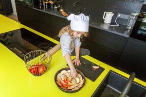 pequeno menina preparando assar caseiro feriado maçã torta dentro cozinha foto