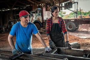 marido e esposa trabalhos juntos dentro uma serraria. família negócios. foto