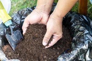 mão segurando a matéria orgânica de turfa melhoram o solo para o cultivo de plantas orgânicas agrícolas, conceito de ecologia. foto