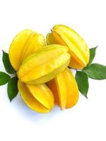 carambola Além disso conhecido Como Estrela fruta, é a fruta do averrhoa carambola, uma espécies do árvore nativo para tropical sudeste Ásia. Estrela fruta com verde folhas isolado em uma branco fundo foto