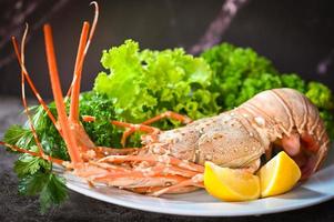 espinhoso lagosta Comida em placa, fresco lagosta ou Rocha lagosta frutos do mar com erva e especiarias limão coentro salsinha alface salada, lagosta para cozinhando Comida e frutos do mar molho foto