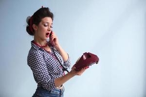 lindo retro menina com uma telefone. mulher dentro a estilo do a anos cinquenta. foto