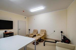 relaxamento quarto com cadeiras e exercício equipamento dentro escritório para descansar e relaxar do funcionários foto