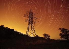 espaço energia, transmissão torre contra Estrela trilhas dentro noite céu foto