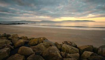 lindo costeiro nascer do sol panorama cenário do arenoso Silverstrand de praia dentro galway, Irlanda foto