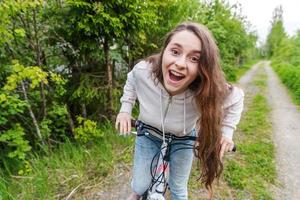 jovem andando de bicicleta no parque da cidade de verão ao ar livre. pessoas ativas. garota hipster relaxar e andar de bicicleta foto