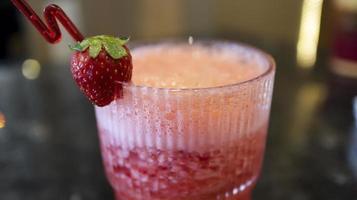 uma vidro do morango suco às a mesa com uma chique canudo. foto