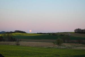 Aumentar lua acima Campos dentro Primavera foto