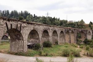 velha ponte ferroviária, velho viaduto vorokhta, ucrânia. montanhas dos cárpatos, paisagem montanhosa selvagem foto