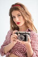 lindo menina com retro Câmera. mulher fotógrafo dentro a estilo do a anos cinquenta foto