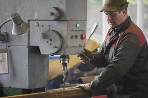 trabalhador às a atual máquina dentro a oficina. foto