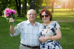 feliz idosos casal com uma ramalhete do flores foto