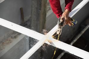 o homem da construção está soldando a estrutura do telhado de aço, as pessoas que trabalham no conceito de canteiro de obras foto