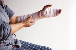 closeup mão enrolada com bandagem no pulso entorse, tratamento de braço de lesão. conceito, problema de saúde, acidente, primeiros socorros. seguro. foto