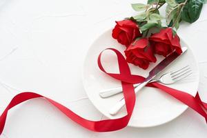 mesa configuração namorados jantar com vermelho rosa em branco prato mesa Comida fundo. conceito do namorados jantar Comida fundo. namorados jantar amor foto