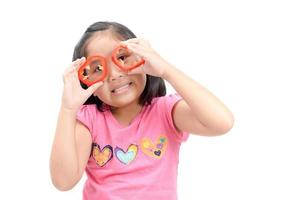 criança menina tendo Diversão com Comida legumes foto