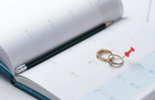 Casamento ouro argolas em calendário com lápis. foto