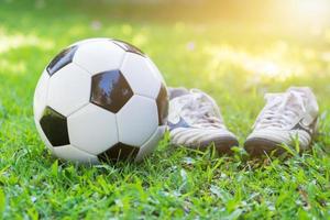 futebol em verde Relva e viga sapato com Sol luz foto