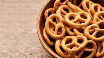 fechar acima mini salgado pretzel dentro uma de madeira tigela em madeira mesa fundo. cópia de espaço foto