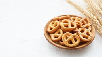 mini salgado pretzel dentro uma de madeira prato em branco mesa fundo. foto