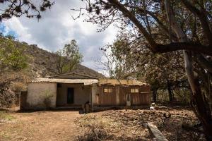 a abandonado rural casa dentro a montanhas com cacto foto