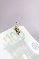 pessoas em miniatura, alpinista sobe em uma nota de euro, conceito de negócio. foto
