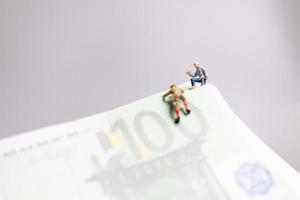 pessoas em miniatura, alpinista sobe em uma nota de euro, conceito de negócio. foto