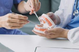 dentistas estão discutindo problemas dentários na imagem de raio-x do relatório na tela do laptop para os pacientes. foto