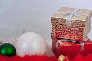 dois presente caixas e dois Natal bolas em branco e vermelho pele com uma branco fundo. foto