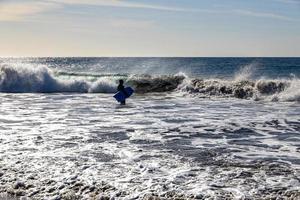 surfista em uma fundo do rude oceanos em uma caloroso ensolarado verão dia, foto