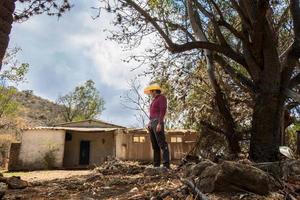 homem com uma vaqueiro chapéu olhando às a abandonado casa do dele avós dentro México foto