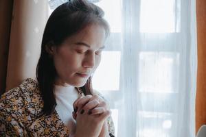 uma mulher está orando com os olhos fechados. foto