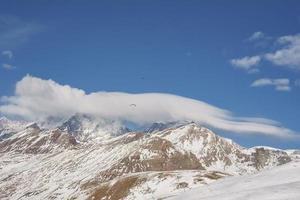 lindo Visão do majestoso coberto de neve montanhas debaixo azul céu foto