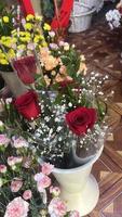 ramalhete do vermelho rosas e cravos dentro uma flor fazer compras foto