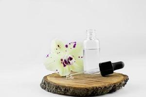 Cosmético sérum dentro uma transparente garrafa com uma pipeta. sérum garrafa em branco fundo. orquídea garrafa. foto